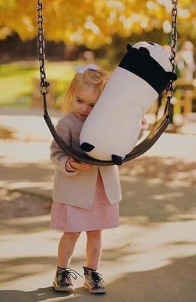 Picture of a sad little girl standing at a swing