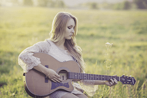 Woman Outside Playing a Guitar - Influence