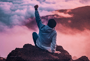 Man celebrating on the top of a mountain